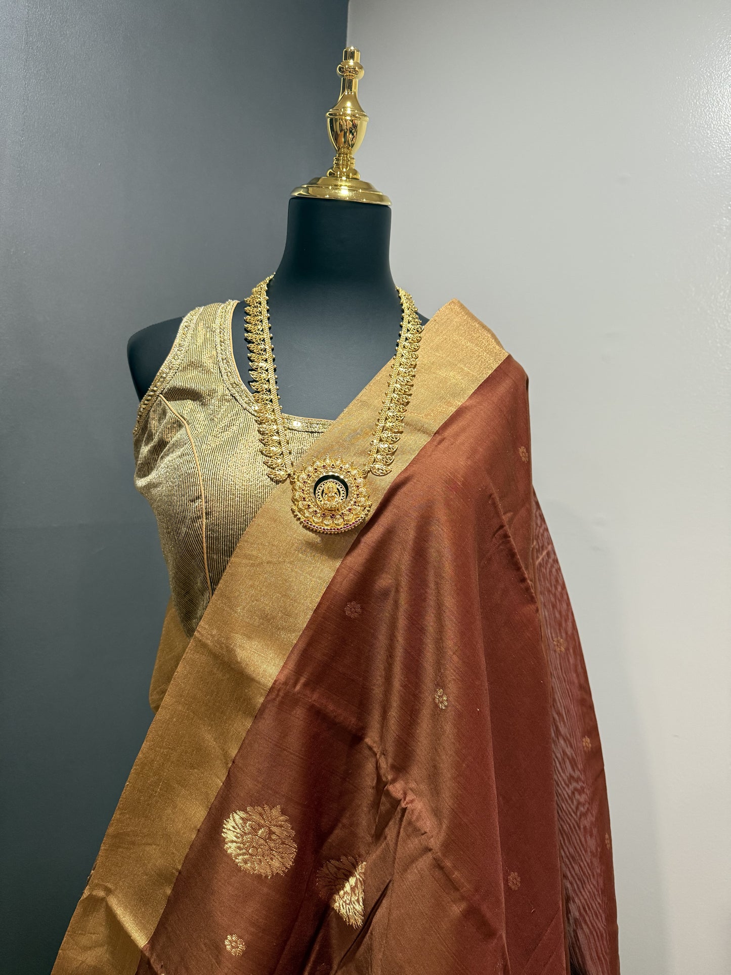 Rust Chanderi Silk saree with golden tissue border and floral buttas.